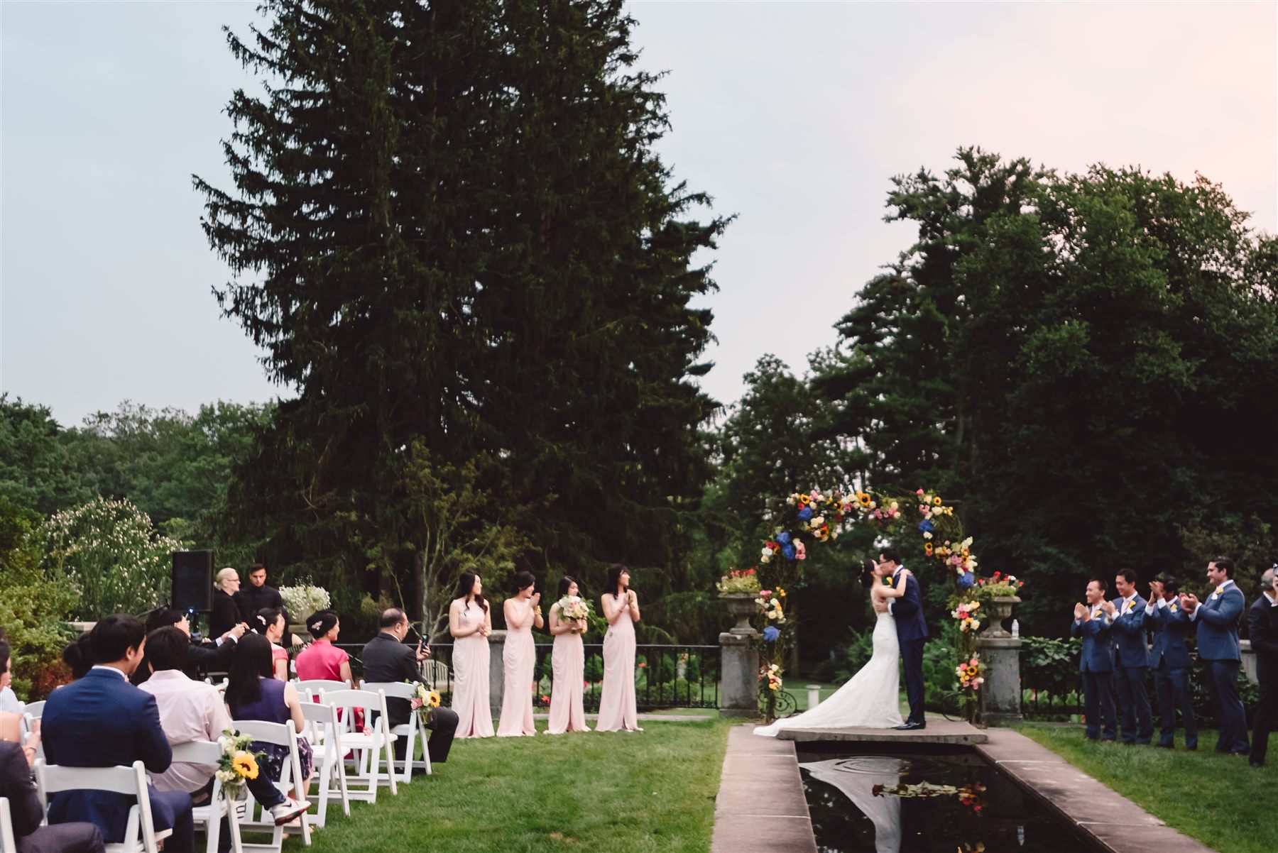 Couple at their vows beside the reflecting pool, Skylands Manor
