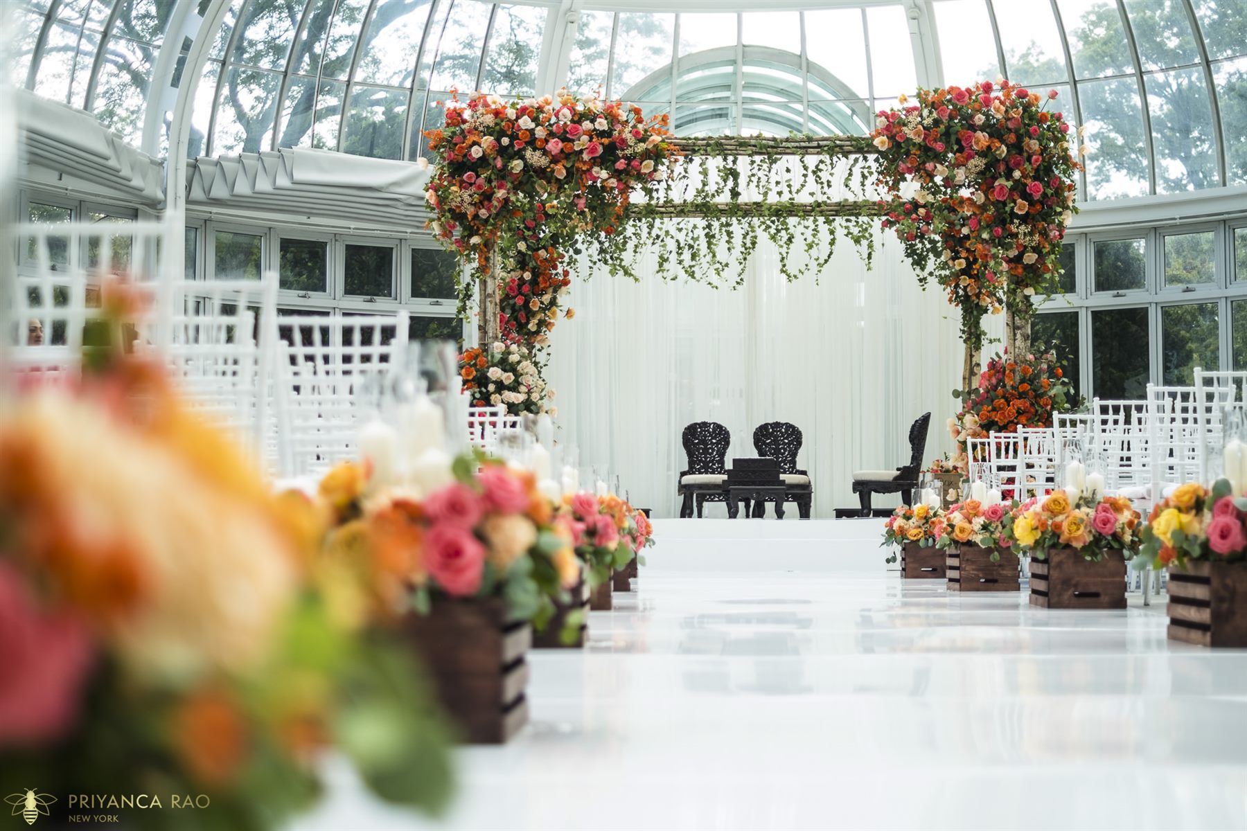 The Palm House dome, a mandap of coral roses at its center
