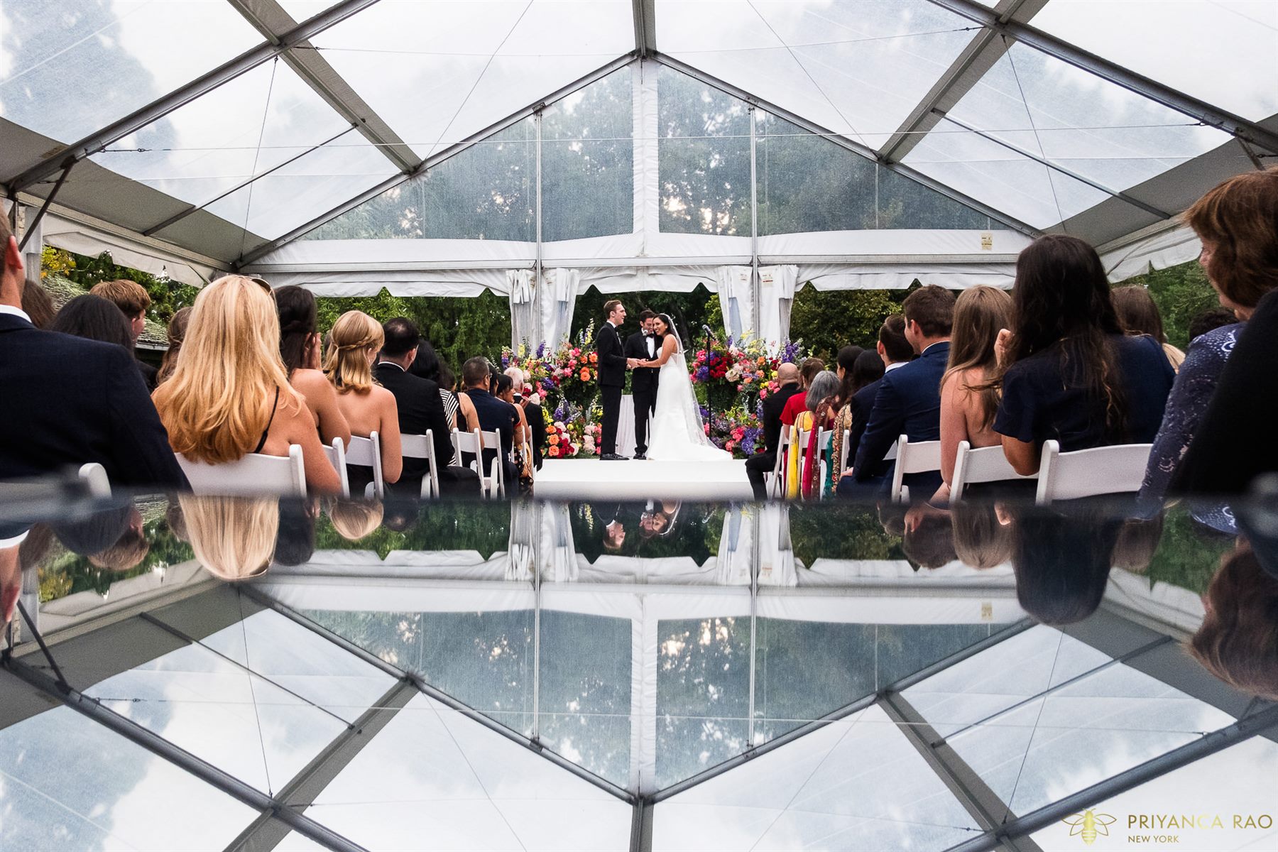 A clear-tent reception over the reflecting pool at Pleasantdale Chateau, planned by Tara M. Events